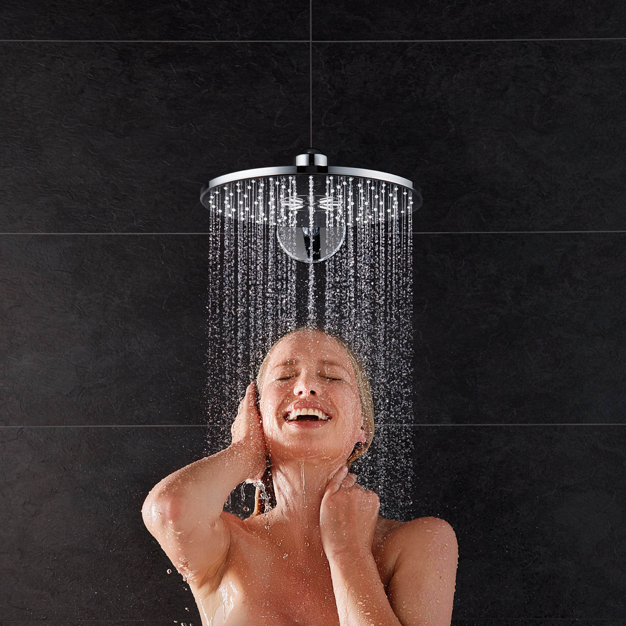 person showering under round rainshower showerhead